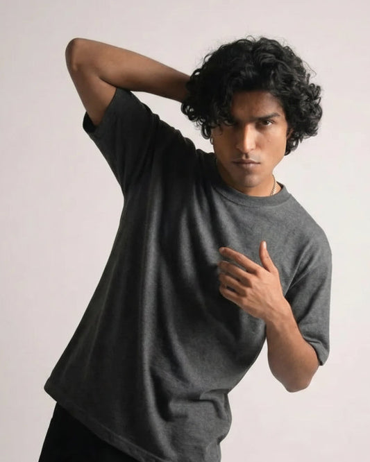 Man wearing a gray sweater and black pants against a light background